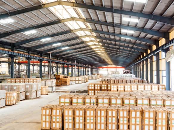 Interior of a San Fernando Valley industrial warehouse with rows of palletized goods, high clear height, and skylights